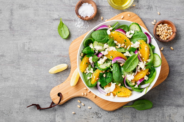 Fresh spinach salad with oranges, feta (ricotta) cheese, red oni