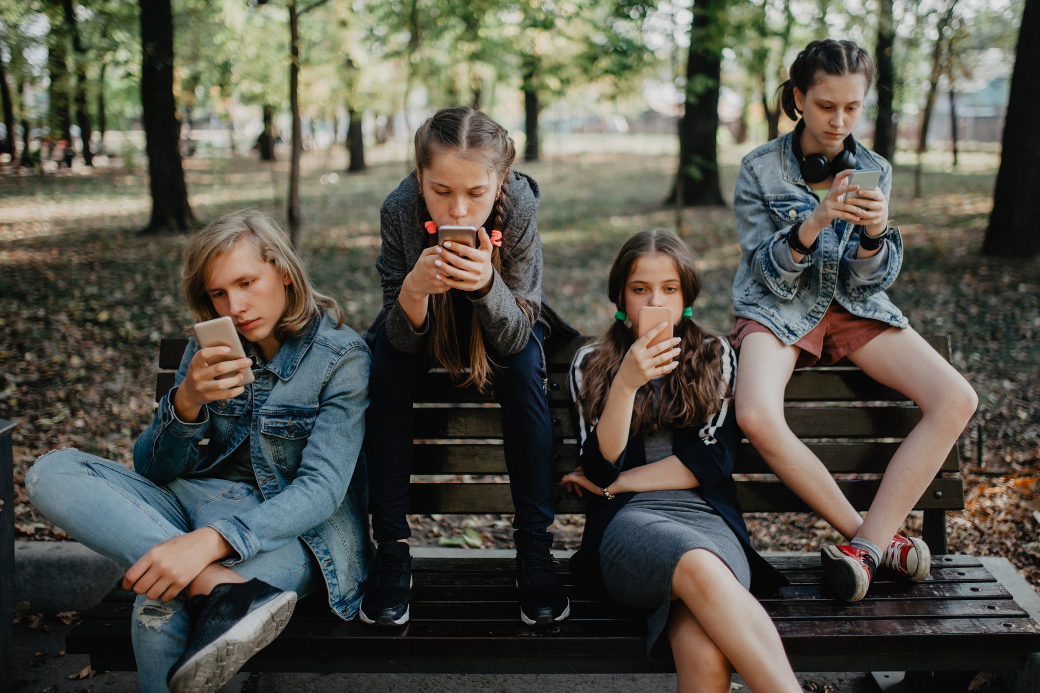 Teenagers in the public park using smartphones
