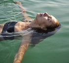 Mature woman floating in a lake with closed eyes