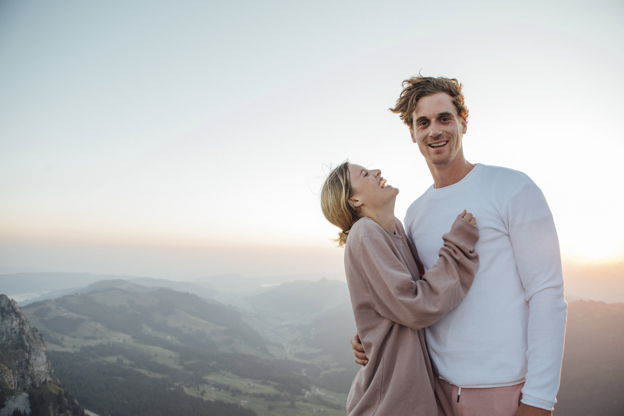 Switzerland, Grosser Mythen, portrait of happy young couple standing in mountainscape at sunrise