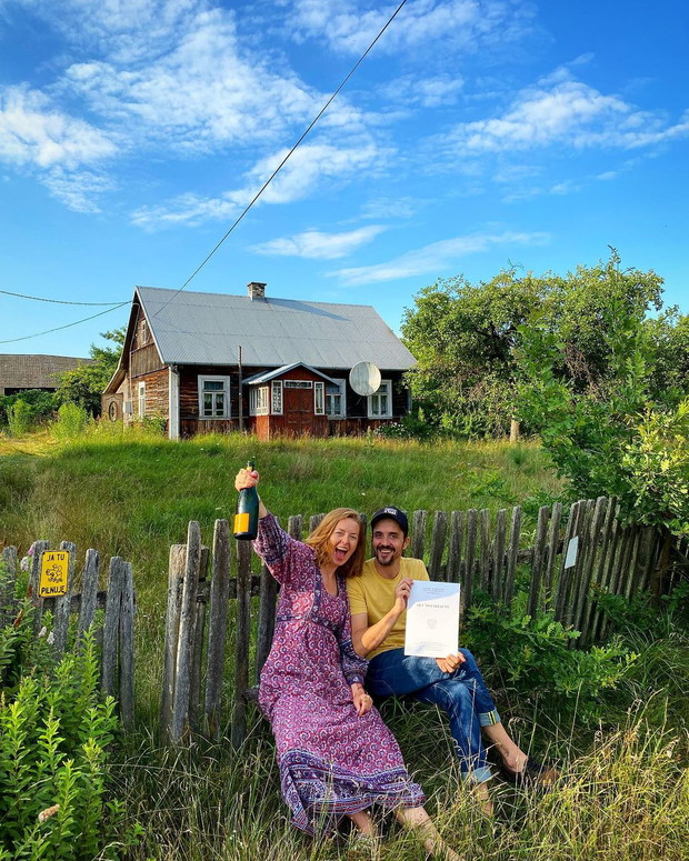 Basia Starecka i Piotr z aktem notarialnym przed chatką