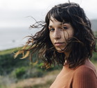 Portrait of confident woman with freckles standing against sky