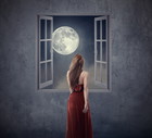 Beautiful woman walking to opened window with moon