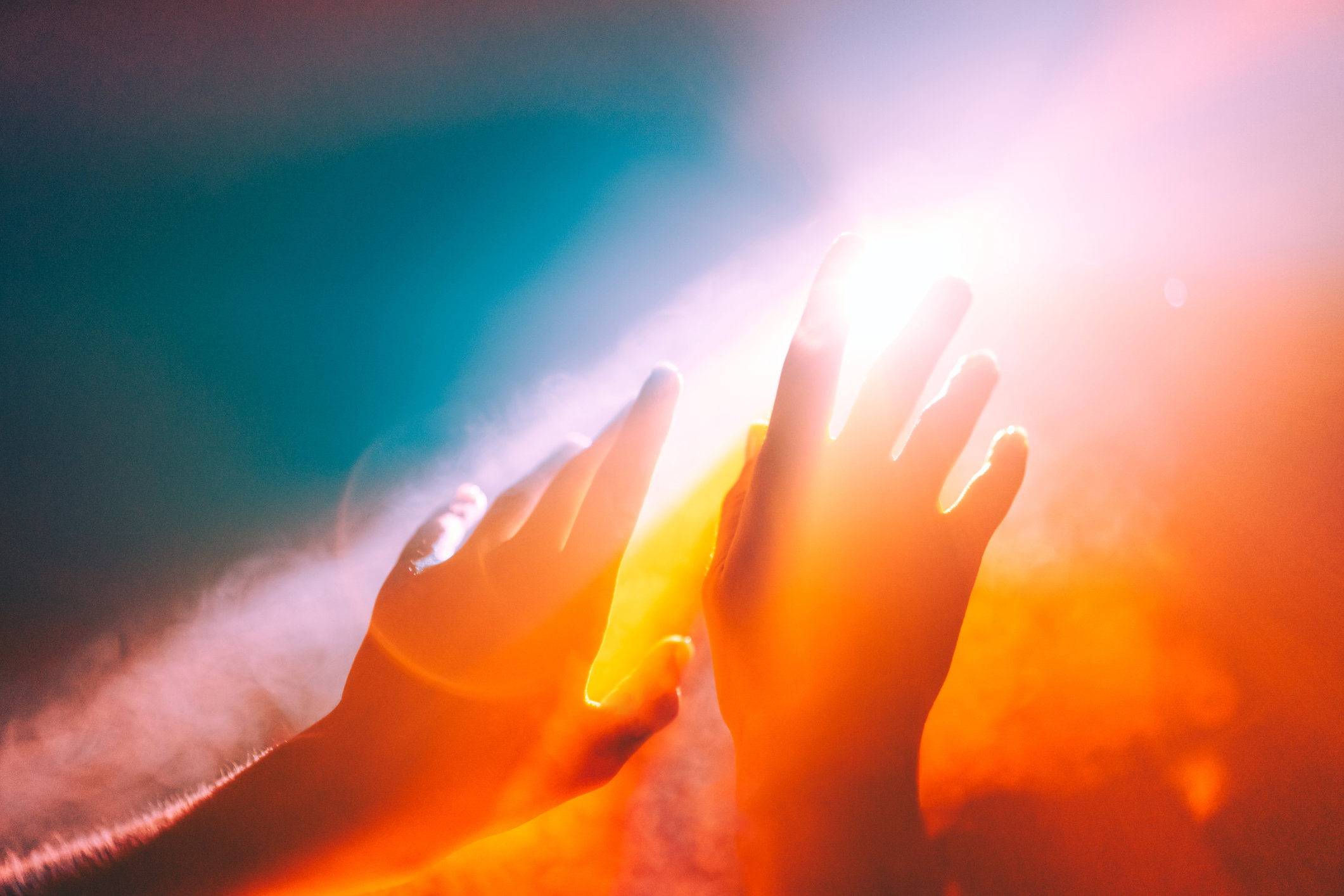 Human hands stretched out to the burning sun, ethereal and unreal concepts of Universe, spiritual and natural powers