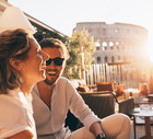 Romantic couple having fun at sunset in Rome, Italy. Colosseum and sunstar