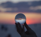 woman's hand with crystal ball Sunset