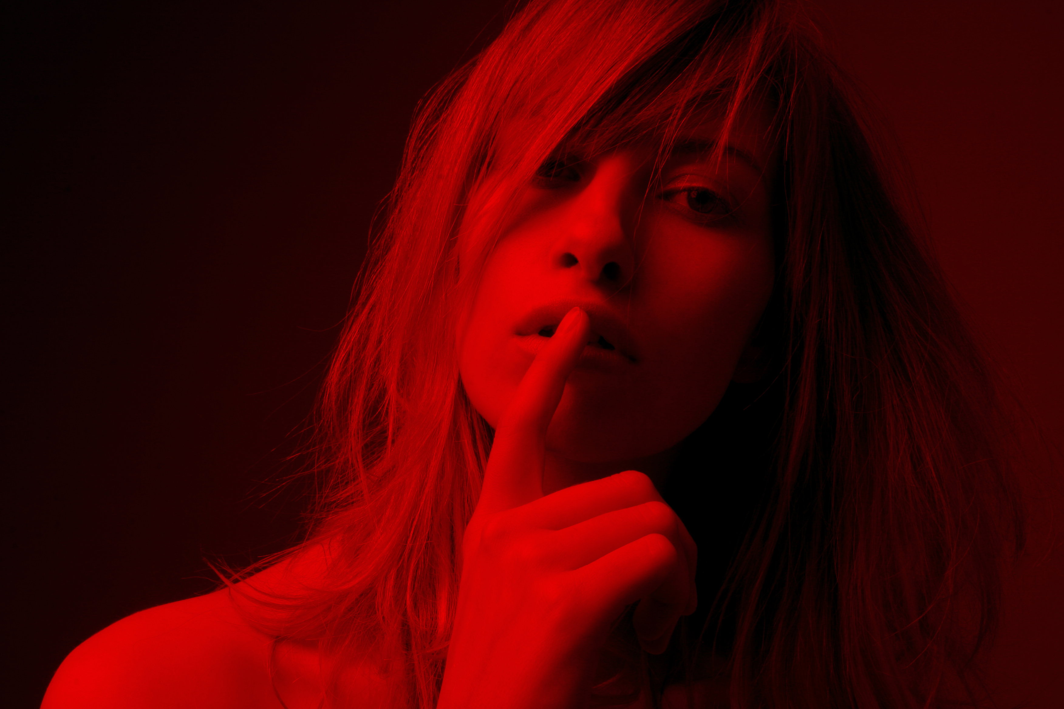 Young woman with finger on mouth