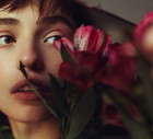 Young woman reflected in mirror with flowers