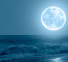 Night sky with blue moon in the clouds sea wave in the foreground