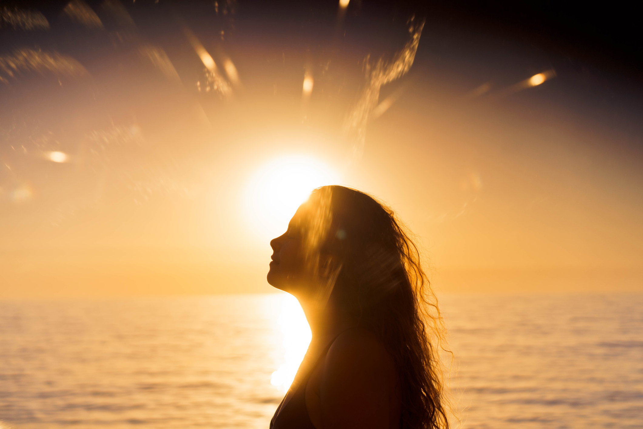 Beautiful woman portrait in sunset light. Black silhouette.