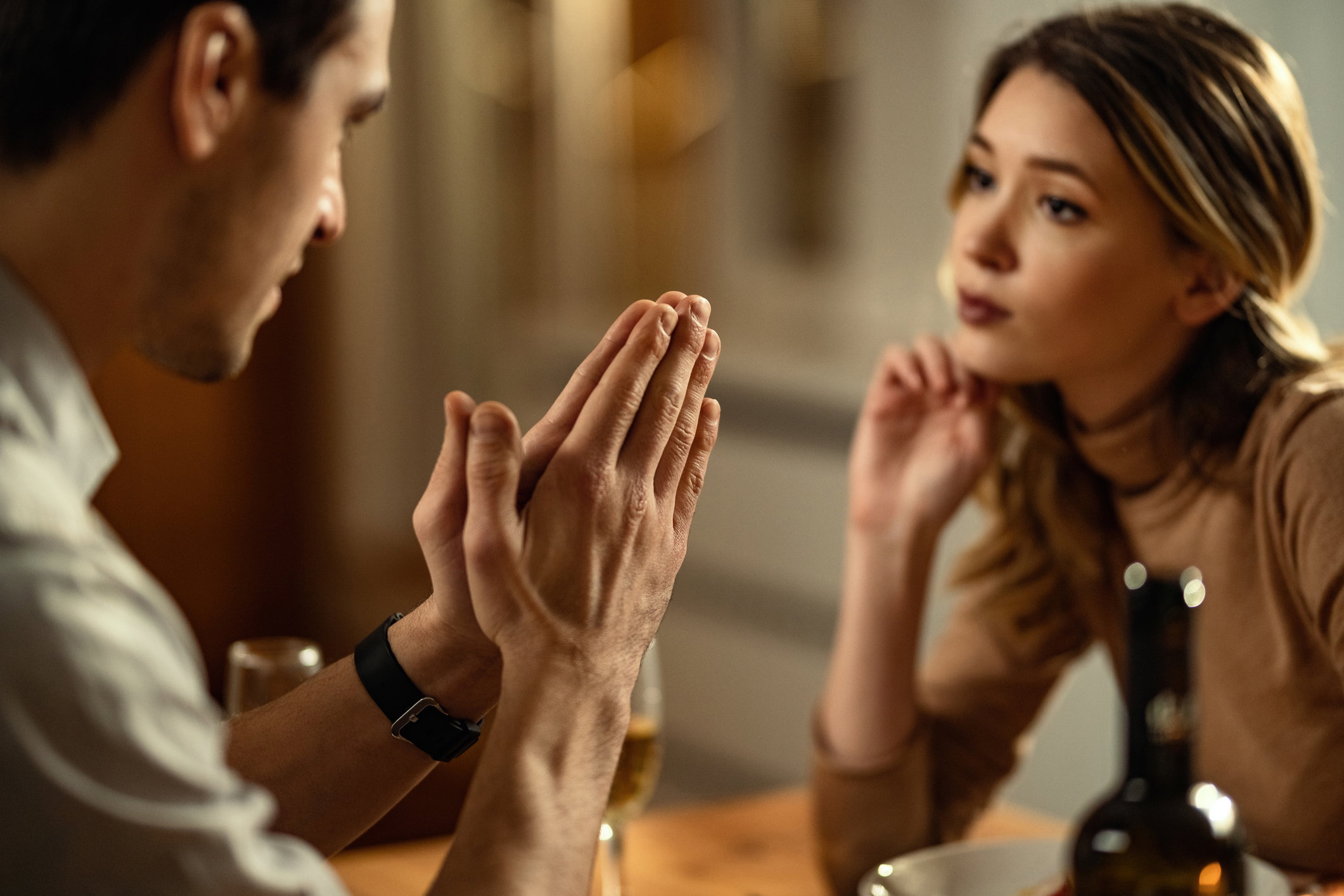 Close-up of man begging his girlfriend for forgiveness.