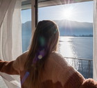 Female opens curtains at sunrise, new beginning new day