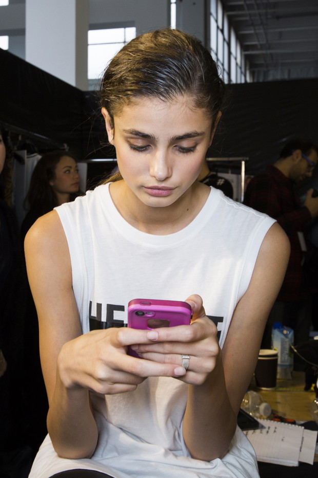 Modelki z telefonami na backstage'u pokazów mody