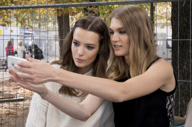 Modelki z telefonami na backstage'u pokazów mody