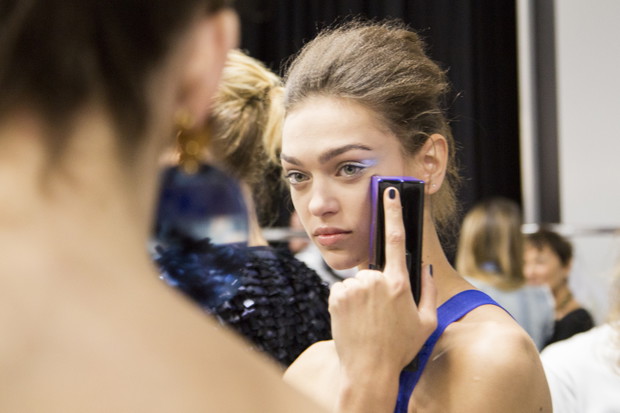 Modelki z telefonami na backstage'u pokazów mody