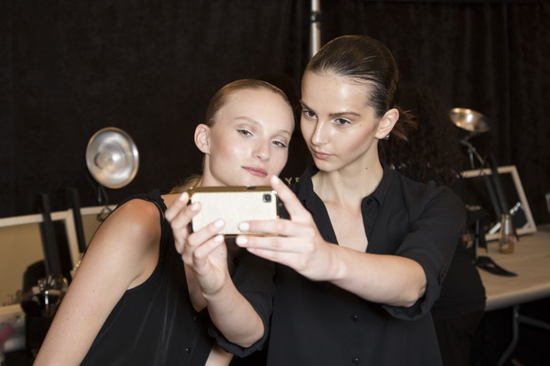 Modelki z telefonami na backstage'u pokazów mody