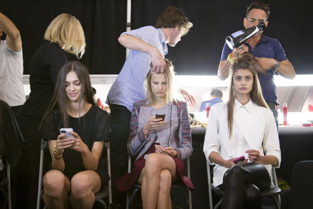 Modelki z telefonami na backstage'u pokazów mody