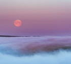 Super Flower Blood Moon over morning fog, Peak District National park.