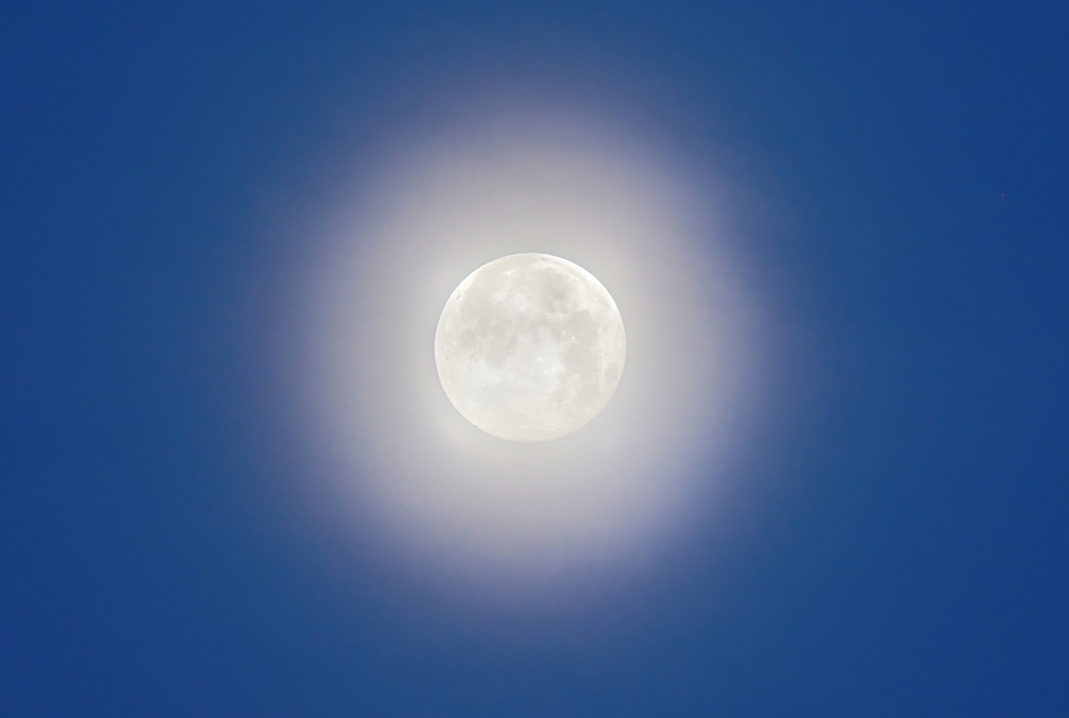 A full moon with moonlight in the blue sky before dawn