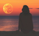 Girl watching the ocean/sea horizon with a Moonrise.