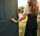 Happy woman jumping next to the open door. Nicely fits for book cover