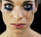 Young woman wearing black eye make-up, crying, close-up