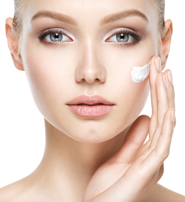 Beauty face of woman with cosmetic cream on face