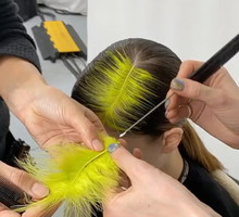 Kolorowe pióro zamiast przedziałka? To uczesanie wygląda jak bardziej wytworna wersja fryzury Billie Eilish. Jest idealne na sylwestra!