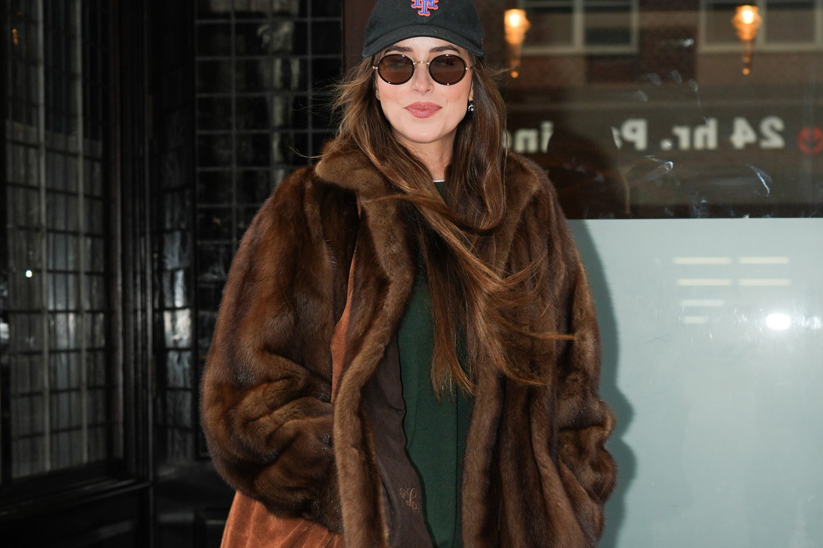 Czekoladowy płaszcz mob wife to mocny trend na jesień. Dakota Johnson zestawia go z wydłużającymi nogi jeansami