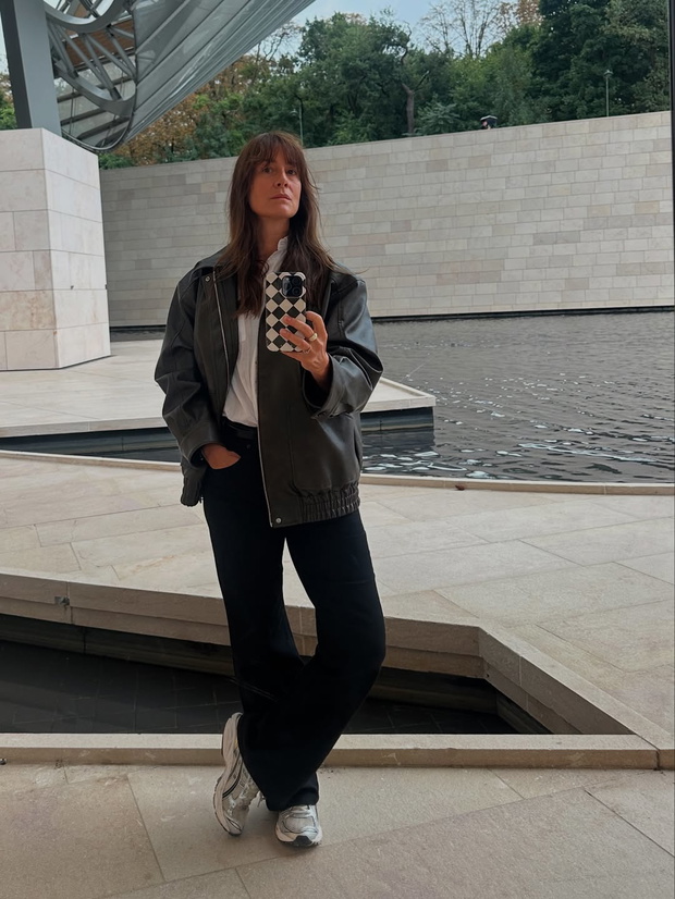 Maja Ostaszewska w czarnej kurtce "bomber jacket" i srebrnych sneakersach ASICS