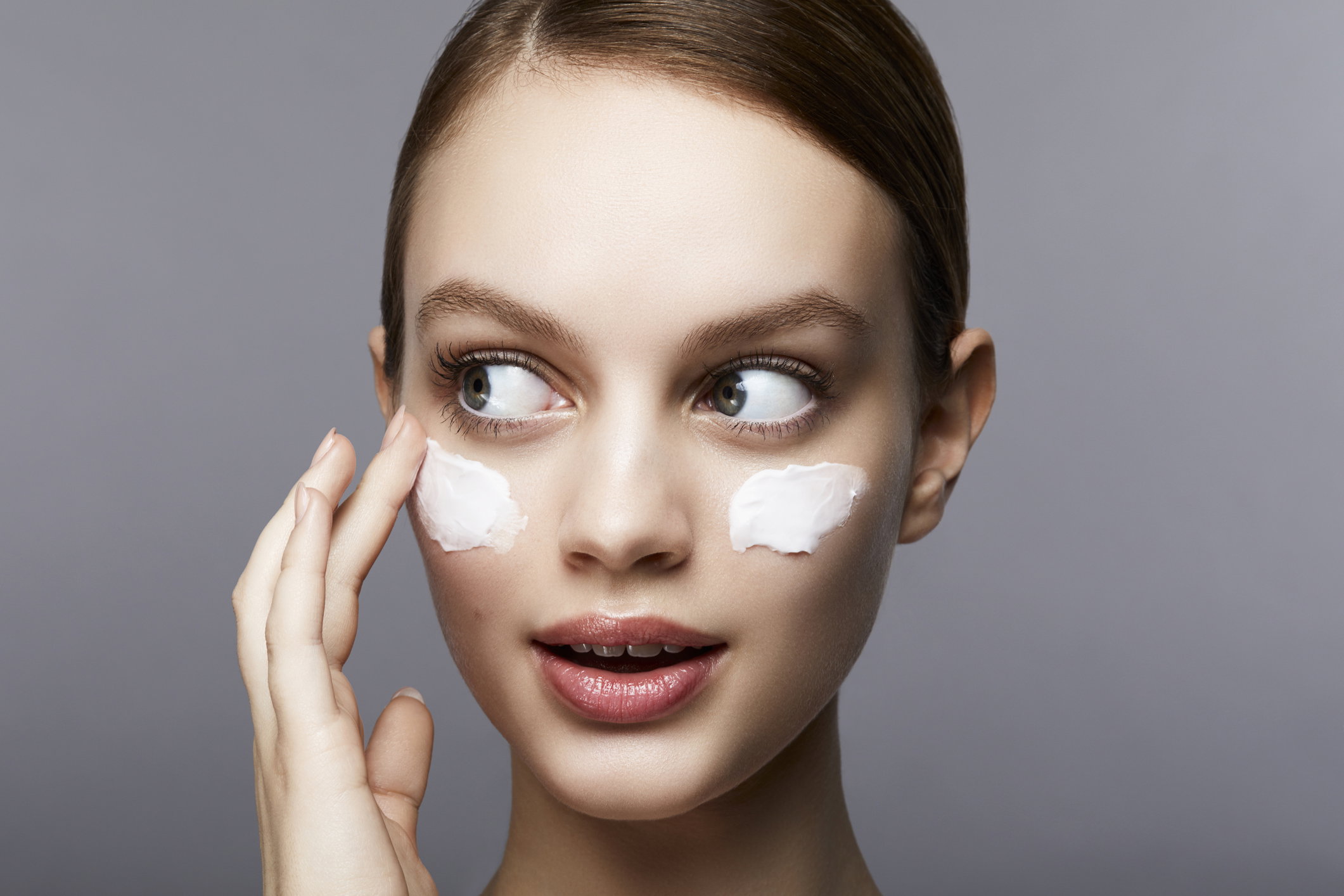 Woman with streaks of lotion on face