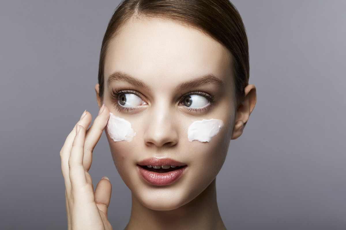 Woman with streaks of lotion on face