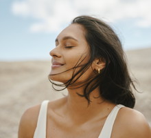 Woman With Glowing Skin Enjoying a Peaceful Breeze in a Serene Natural Setting