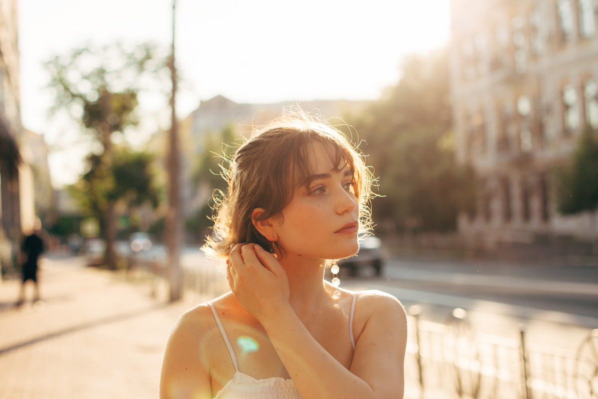 Beautiful young woman walking on the city street during summer