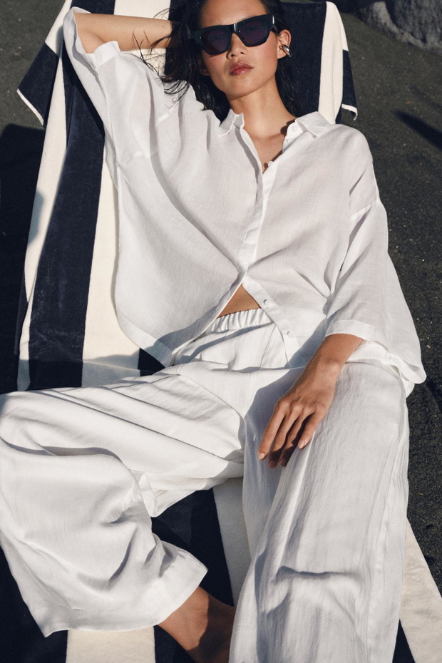 Zwykła biała koszula? W tym sezonie liczy się „oversized button-up”. Ten model z Zary wygląda świetnie narzucony na kostium kąpielowy i szerokie jeansy