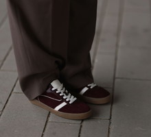 Nie tylko adidas Hanball Spezial. Zamszowe sneakersy w kolorze „cherry coke” podbiją ulice Kopenhagi i Paryża. Idealne na jesień