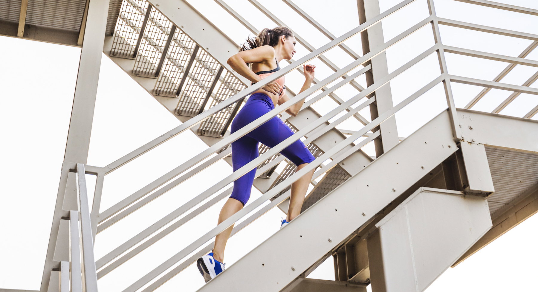Caucasian woman running on urban staircase