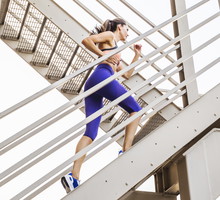 Caucasian woman running on urban staircase