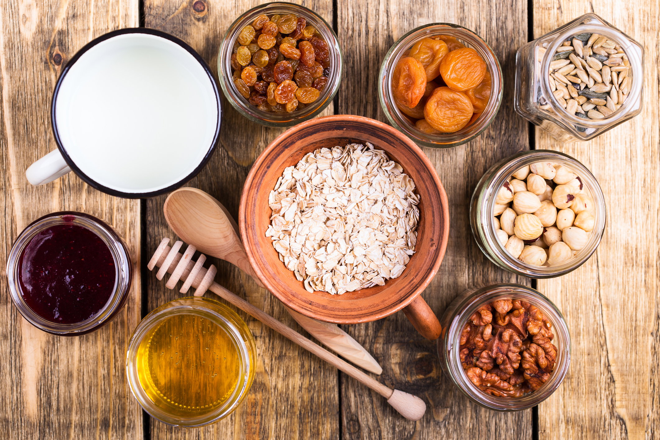 Healthy morning muesli ingredients on rustic wooden board, top view