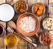 Healthy morning muesli ingredients on rustic wooden board, top view