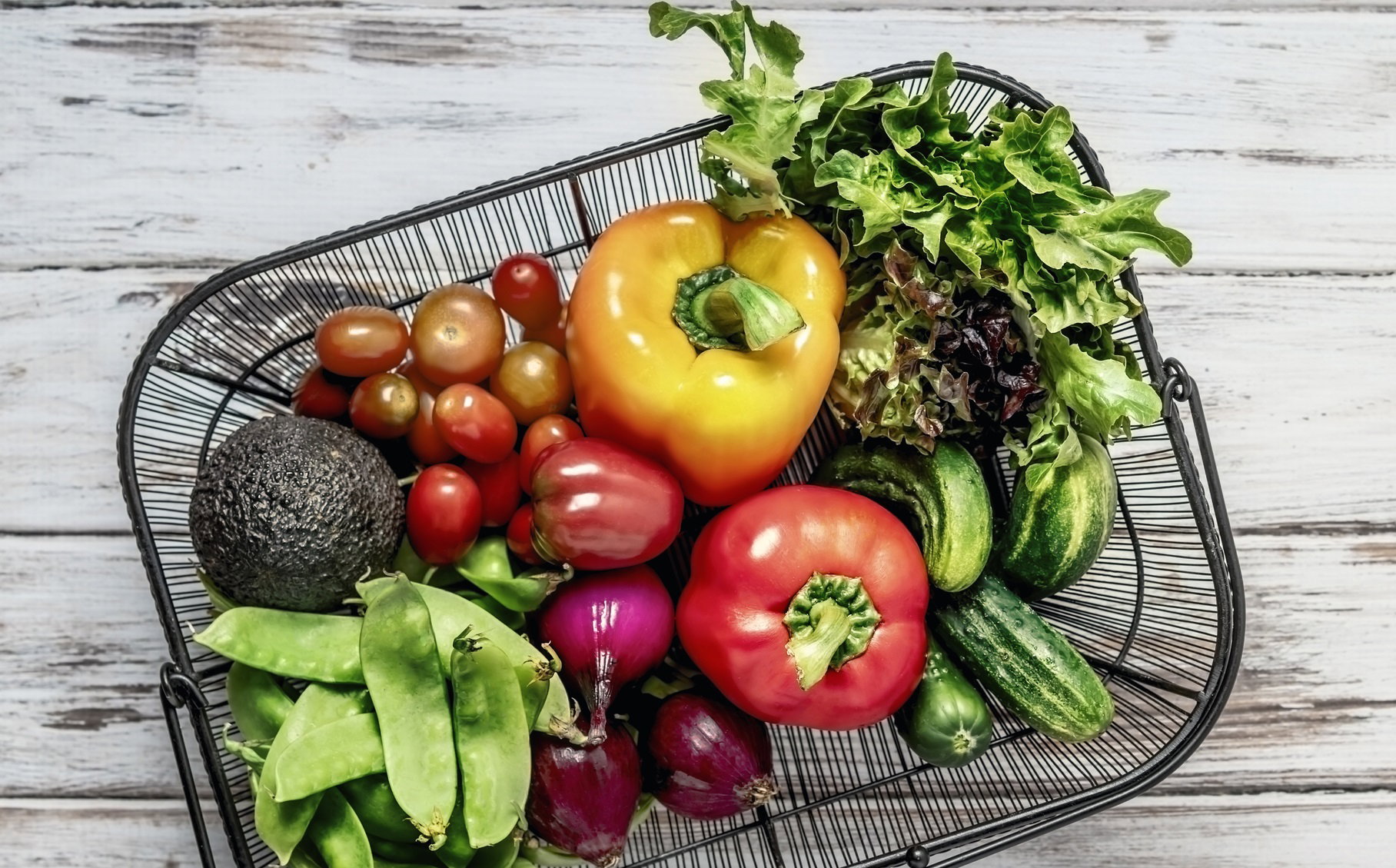 A basket of fresh fruits and vegetables on white background