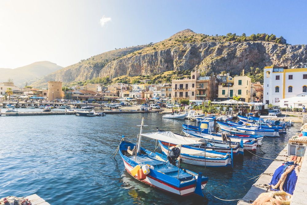 Boats Moored In Harbor Against Buildings In City