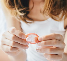Cropped shot view of woman holding a small condom on her hand before using it with her partner.