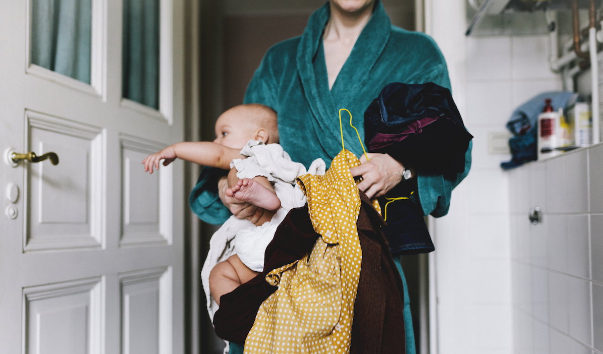 Single Mother With Baby Trying To Get Dressed