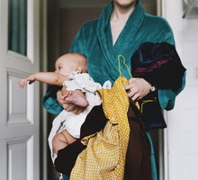 Single Mother With Baby Trying To Get Dressed