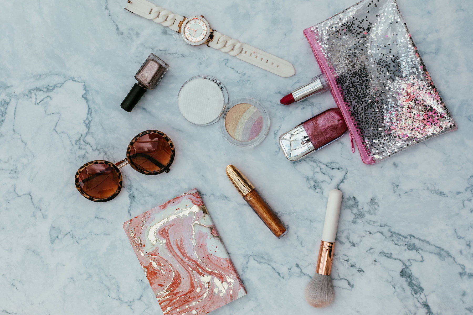 Top view of set female accessories on marble  pink flat lay