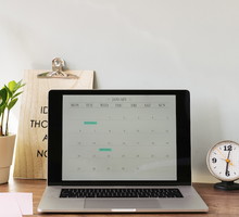 Opened laptop with a calendar on desk at home office