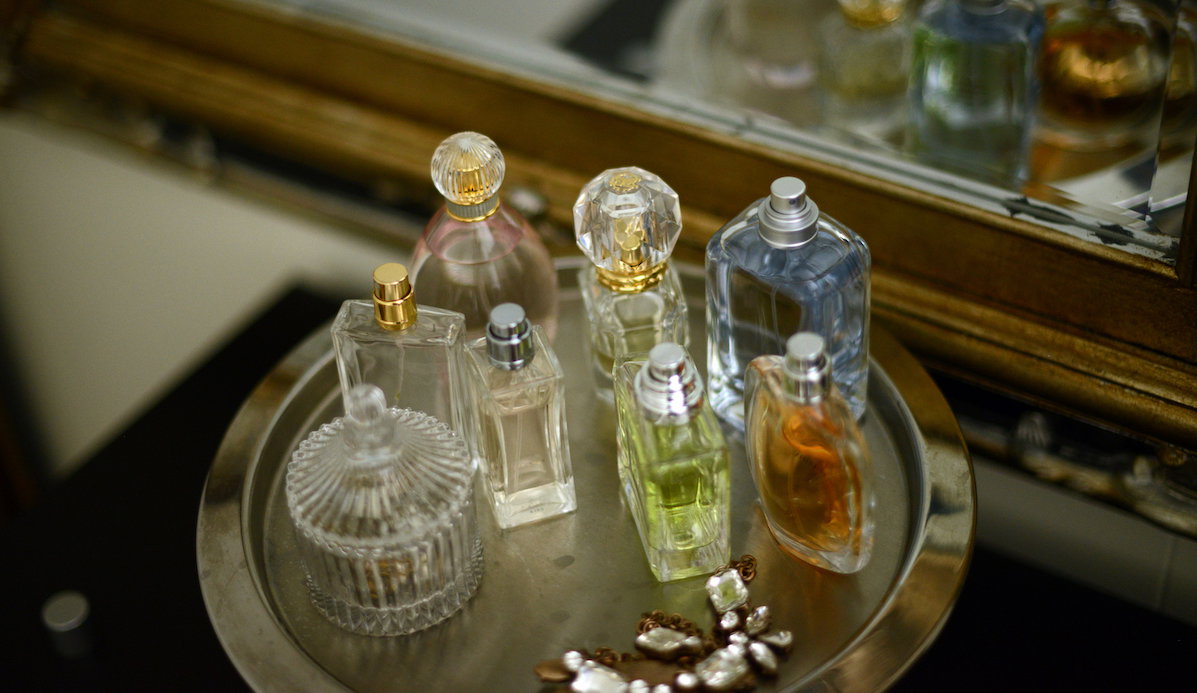 Perfume bottles on a tray by a mirror
