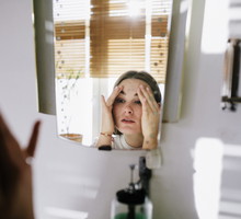 Woman looking in bathroom mirror