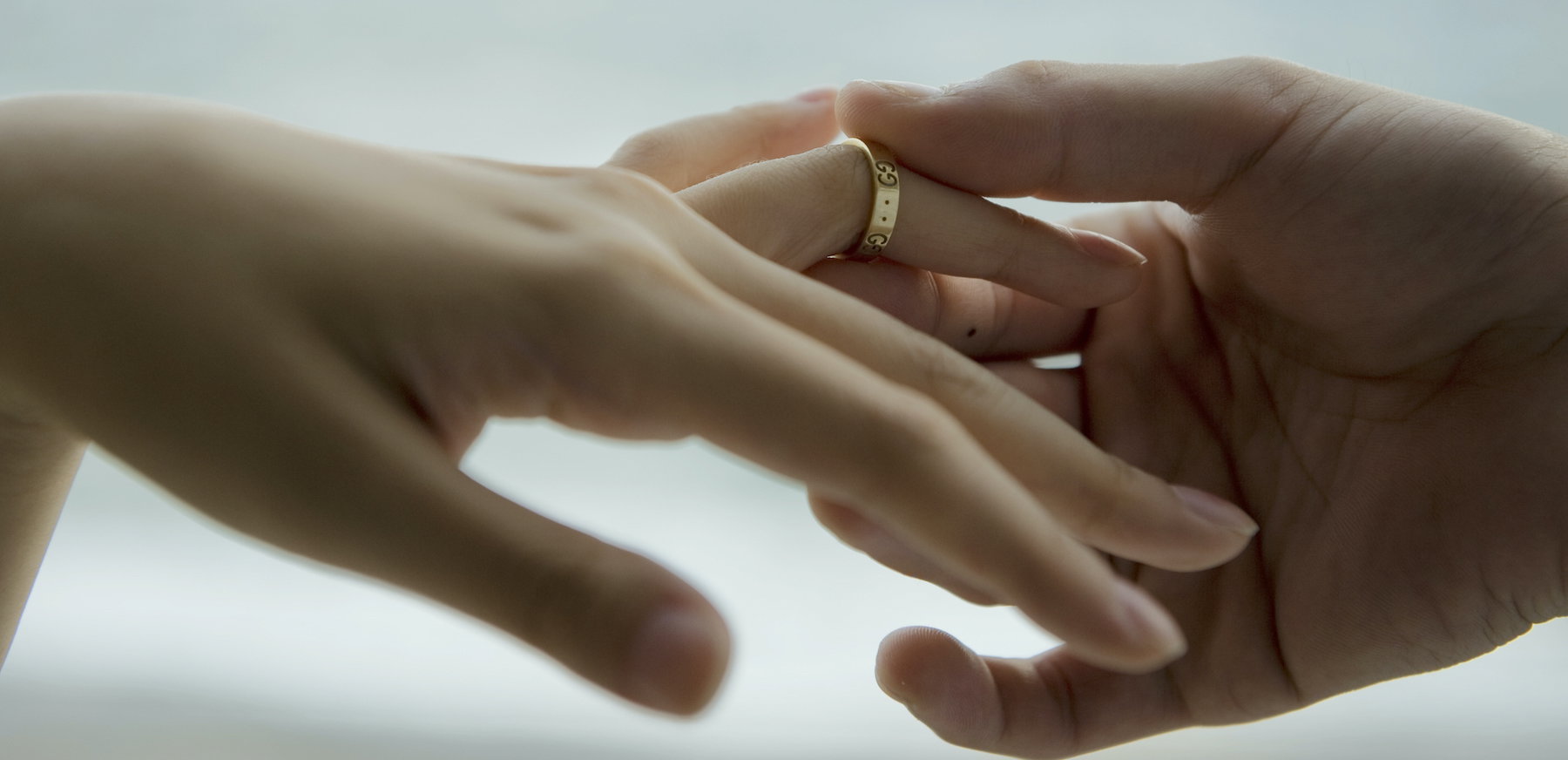 Man placing ring on woman's finger